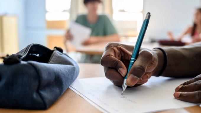 a close up of a hand with a pen writing