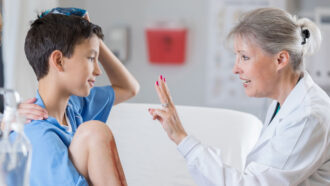 a doctor examines a young boy who seems to have a head injury