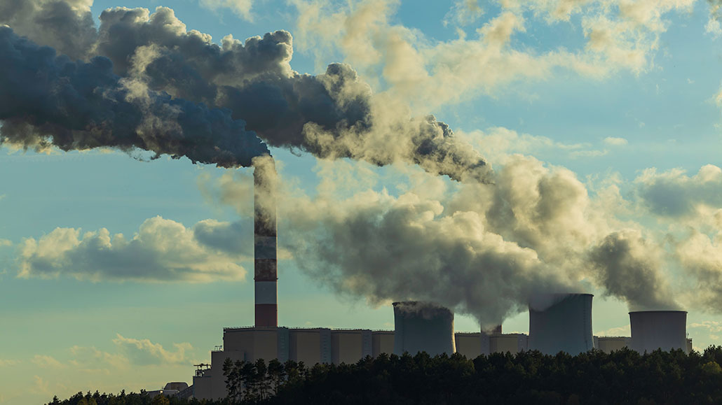 steam coming out of a coal-fired power plant chimney as seen from a distance