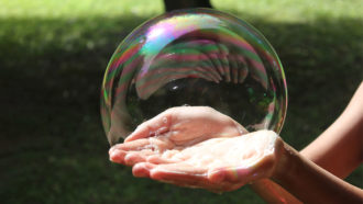 hands holding a large soap bubble