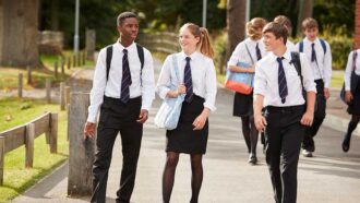 a group of students walking outside wearing school uniforms