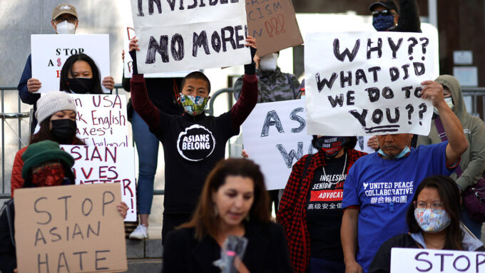 a photo of various Asian adults protesting and holding signs. One of the signs reads "Stop Asian Hate"