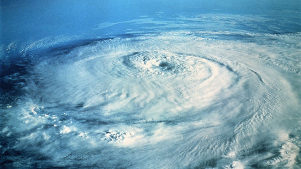 a photo from space looks down on the swirling clouds of a hurricane